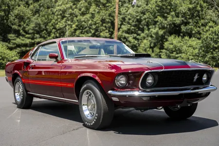 1969 Ford Mustang Mach 1 in red with black hood stripe, front three-quarter view